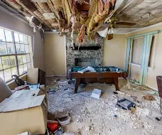 Damaged ceiling with exposed insulation above an affected room