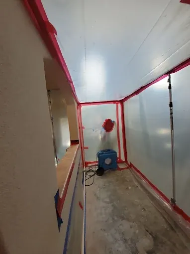 Red tape and plastic sheeting enclosing an interior doorway